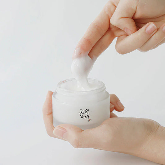 Démonstration de la texture onctueuse et riche de la Dynasty Cream de Beauty of Joseon, prélevée au doigt dans son pot en verre dépoli pour illustrer sa densité hydratante.