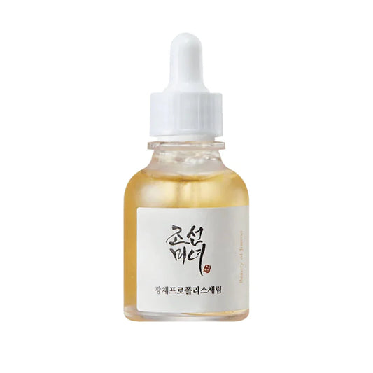 Sérum Glow Serum Propolis+Niacinamide de chez Beauty Of Joseon dans un flacon en verre transparent laissant voir la couleur jaune du sérum, applicateur pipette, sur fond blanc.
