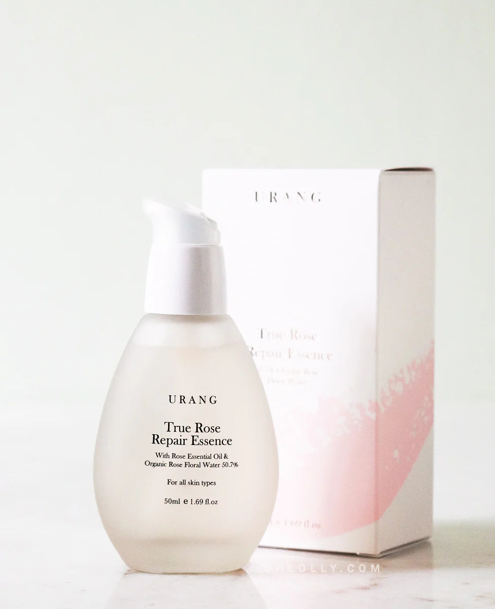 Urang True Rose Repair Essence dans son flacon en verre devant son packaging blanc et rose en carton