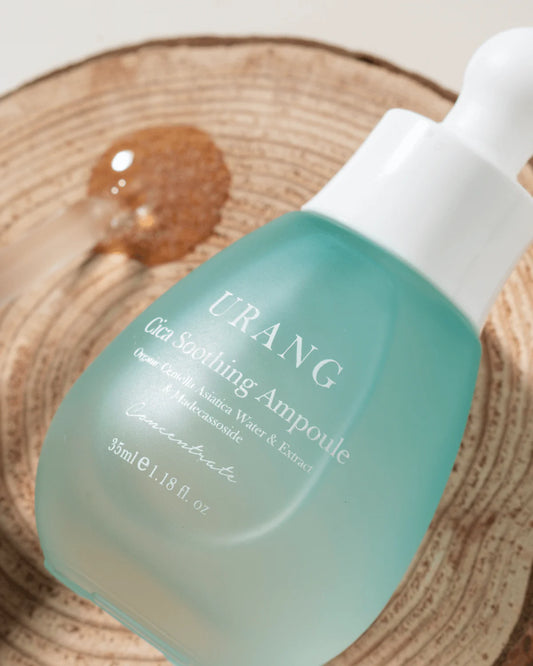 Urang cica soothing ampoule dans son packaging en verre sur une planche de bois