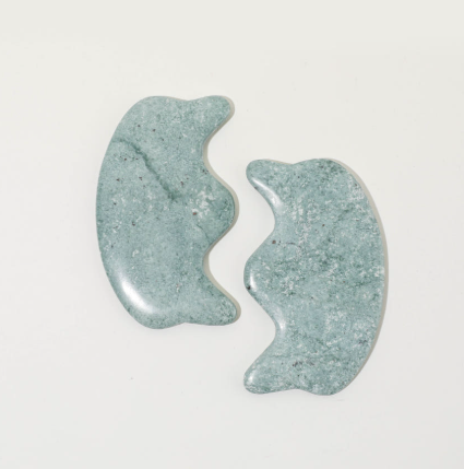 Paire d'outils de massage facial Gua Sha de forme ergonomique « couronne », en pierre de jade côte à côte pour un soin du visage décongestionnant et sculptant.