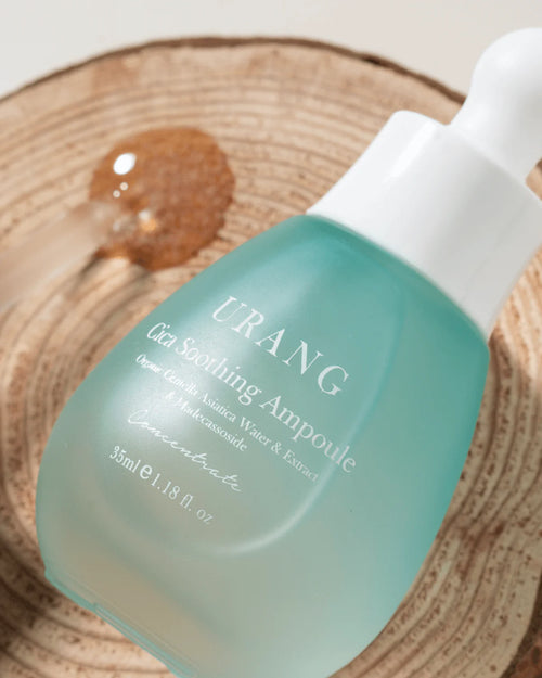 Urang cica soothing ampoule dans son packaging en verre sur une planche de bois